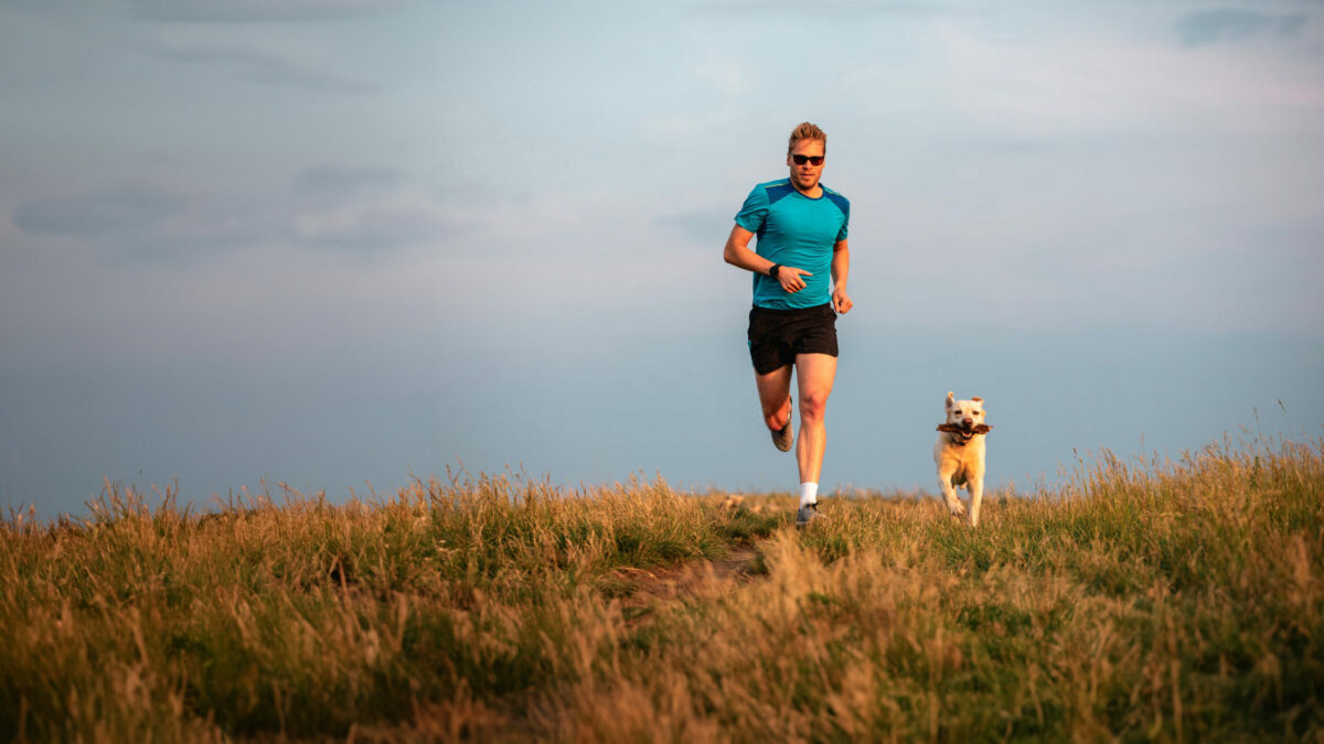 Sportlicher Lebensstil mit Hund. Sportlichen Mann läuft mit Labrador Retriever zusammen.